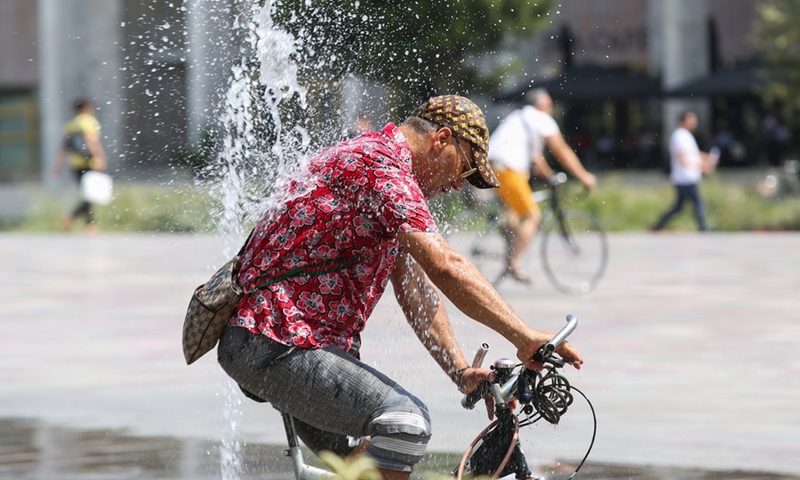 A man rides a bicycle through fountains at Skanderbeg Square in the center of capital Tirana, Albania, July 29, 2021.Photo:Xinhua