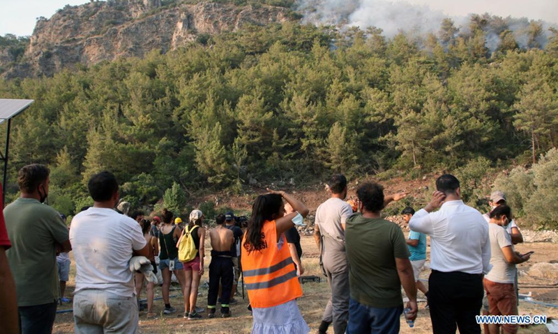 People look at the smoke from wildfires in Marmaris, Mugla province, southwestern Turkey, on Aug. 5, 2021. Turkey has been battling massive wildfires that had erupted in southern and southwestern coastal resort towns for over one week. The blazes have claimed eight lives.Photo:Xinhua