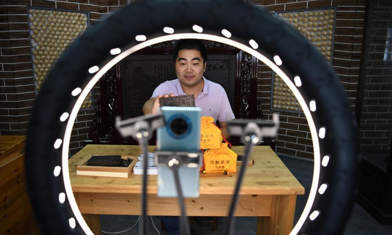 A worker introduces Yixian dark tea artwork through livestream broadcasting at a studio in Yixian County, east China's Anhui Province, July 30, 2021.Photo:Xinhua