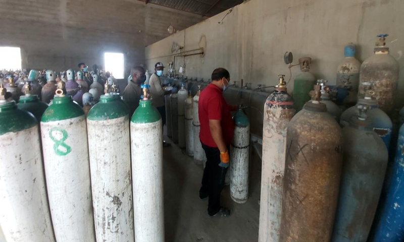 Workers fill up oxygen cylinders at a medical oxygen plant in Tajura, Libya, on Aug. 8, 2021. The Libyan Ministry of Health has provided oxygen supplies to some hospitals in the capital Tripoli. Major hospitals in the city recently suffered from a severe lack of oxygen, as the country continues to record new COVID-19 cases.(Photo: Xinhua)