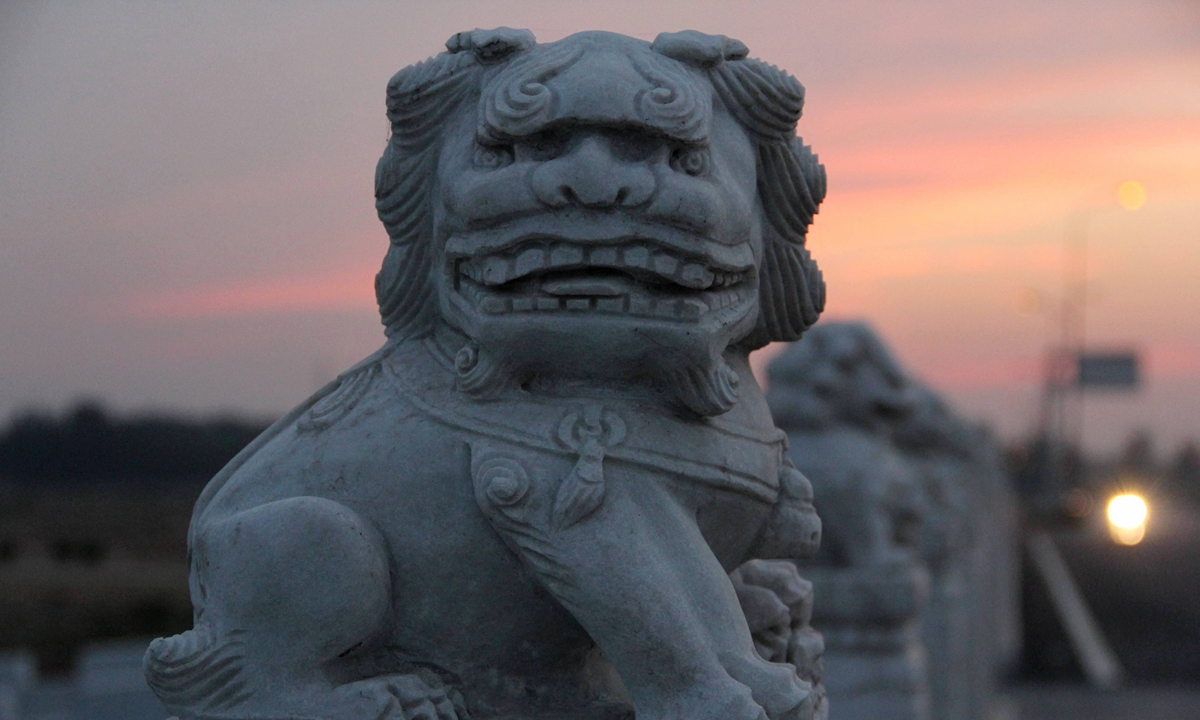 A cute stone lion is seen standing on a bridge with a big smile in Binzhou, East China's Shandong Province, on World Lion Day, which falls on Tuesday in 2021. Photo: IC