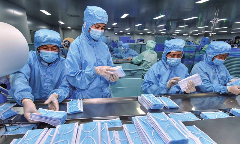 Employees package facial masks at a medical equipment supplier in Qingzhou, East China's Shandong Province on Thursday. Many local manufacturers of anti-virus supplies have over recent days raced to finish orders for masks, gloves and disinfectants, playing their part in virus containment efforts. Photo: cnsphoto