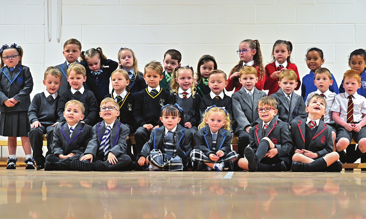 Thirteen sets of twins due to start the new school term in the Inverclyde area pose for a photograph at St Mary's Primary on Wednesday in Greenock, Scotland. Schools in the area have added to their tally of twins, as Scottish pupils start returning from their summer break following most COVID-19 restrictions being lifted. Photo: VCG