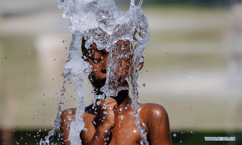 A kid cools off at a fountain during hot weather in Nice, France, Aug. 14, 2021. (Photo by Serge Haouzi/Xinhua)