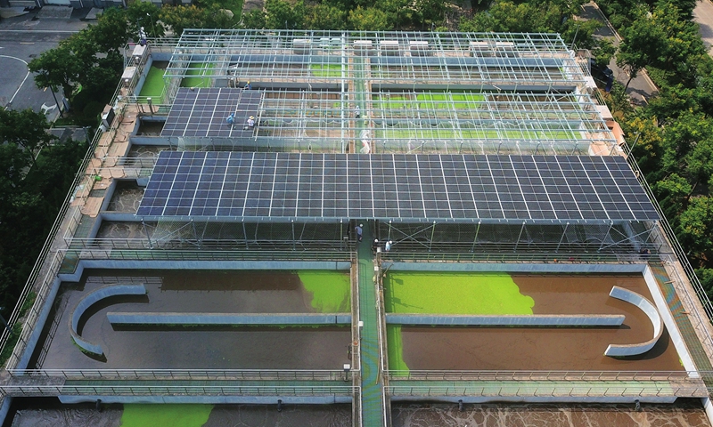 Workers assemble solar panels at a wastewater treatment plant in Lianyungang, East China's Jiangsu Province on Sunday. The city's first solar power generation project that eyes utilizing photovoltaic energy as part of wastewater treatment is being built. The project is expected to generate up to 233,000 kilowatt hours of electricity per annum and reduce electricity costs by about 140,000 yuan ($21,613) annually. Photo: cnsphoto