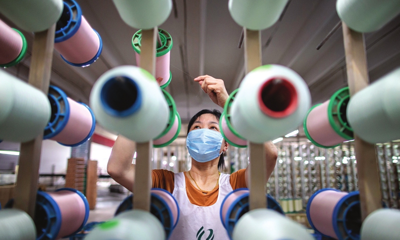 A woman finishes export orders for pure silk products at a workshop in Hai'an, East China's Jiangsu Province on Monday. The city, known as the hometown of cocoons and silk, has been promoting the silk sector, which has annual output of over 10 billion yuan ($1.54 billion), to boost local farmers' incomes and create jobs. Photo: cnsphoto
