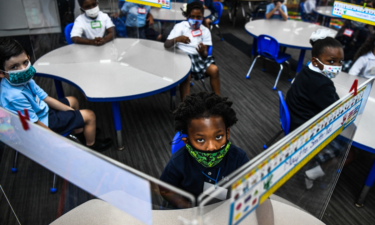 Student wear facemasks at their first day in school after summer vacation at the St. Lawrence Catholic School  north of Miami, Florida, on Wednesday. Florida reported 21,669 new COVID-19 cases on Tuesday, bringing the 7-day average to its highest level of the pandemic. Photo: AFP