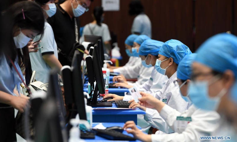 Medical workers record information of the students who are about to receive COVID-19 vaccines at a vaccination site in a middle school in Zhengzhou, central China's Henan Province, Aug. 19, 2021. Zhengzhou recently started COVID-19 vaccination for minors aged between 12 and 17.Photo:Xinhua