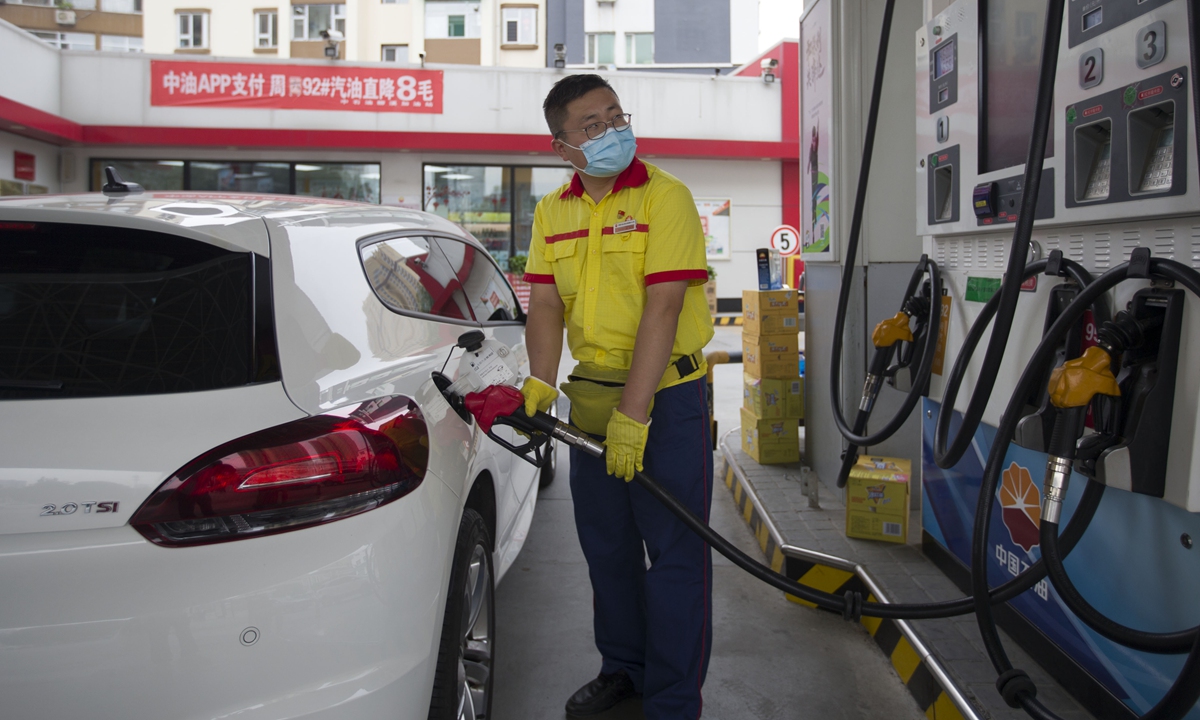 A worker fuels a car in Taiyuan, North China's Shanxi Province on Monday. 
The country's top economic planner  said starting on Tuesday, domestic gasoline and diesel prices will be cut by 250 yuan ($38) and 245 yuan per ton respectively under the current pricing mechanism. Photo: cnsphoto