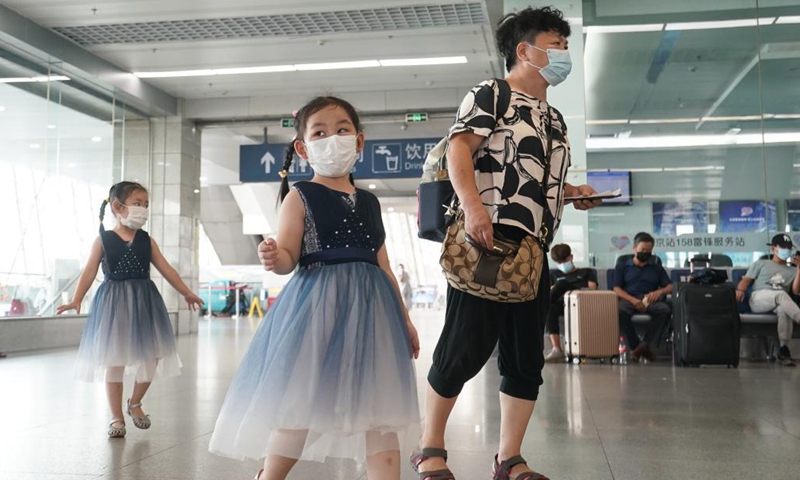 A parent and two girls wait for the train at Nanjing Railway Station in Nanjing, capital of east China's Jiangsu Province, Aug. 23, 2021. Nanjing, which witnessed the country's latest resurgence of coronavirus cluster infections attributable to the Delta variant, cleared all medium- and high-risk areas for COVID-19 on Aug. 19. From Aug. 23, people leaving Nanjing by rail, highway, waterway, etc. will no longer be required to provide negative nucleic acid test certificates. (Xinhua/Ji Chunpeng)