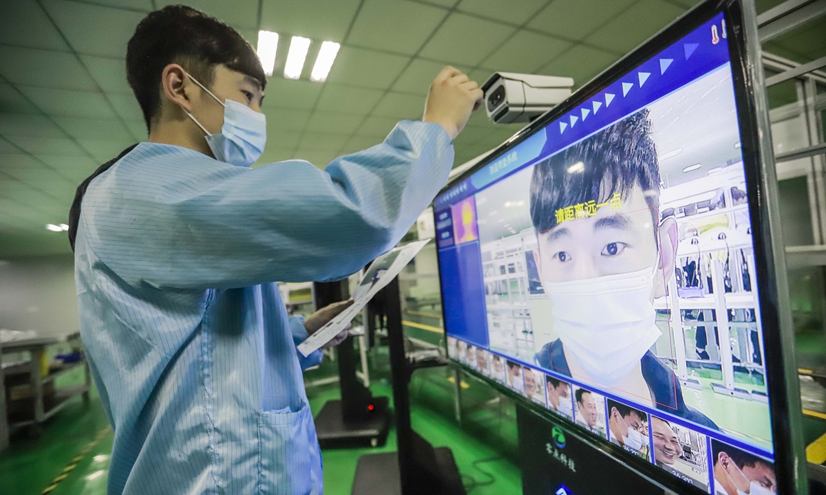 A worker tests temperatures with a thermal imaging camera in Zunhua, North China's Hebei Province on Monday. Large orders for the equipment are rushing as schools in China are ready to start the new semester in September. Photo: cnsphoto