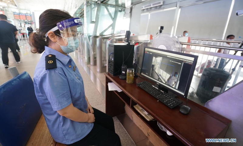 A staff member monitors passengers' body temperature on a computer at Nanjing Railway Station in Nanjing, capital of east China's Jiangsu Province, Aug. 23, 2021. Nanjing, which witnessed the country's latest resurgence of coronavirus cluster infections attributable to the Delta variant, cleared all medium- and high-risk areas for COVID-19 on Aug. 19. From Aug. 23, people leaving Nanjing by rail, highway, waterway, etc. will no longer be required to provide negative nucleic acid test certificates. (Xinhua/Ji Chunpeng)