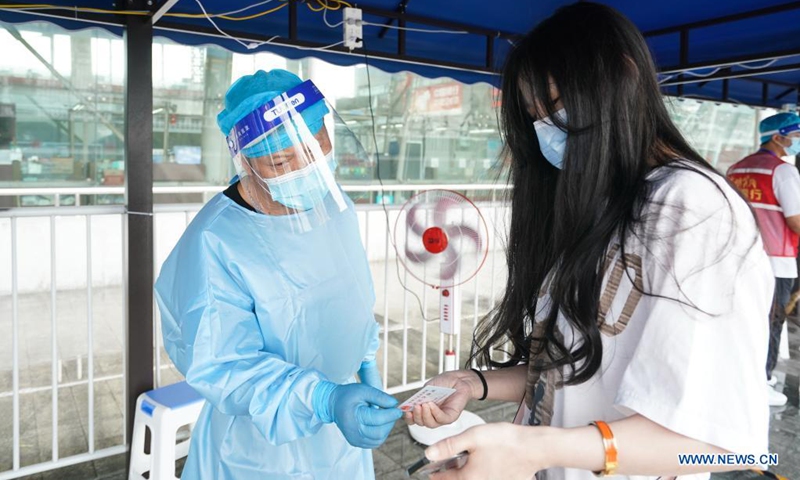 A staff member checks a passenger's identity information and health code at Nanjing Railway Station in Nanjing, capital of east China's Jiangsu Province, Aug. 23, 2021. Nanjing, which witnessed the country's latest resurgence of coronavirus cluster infections attributable to the Delta variant, cleared all medium- and high-risk areas for COVID-19 on Aug. 19. From Aug. 23, people leaving Nanjing by rail, highway, waterway, etc. will no longer be required to provide negative nucleic acid test certificates. (Xinhua/Ji Chunpeng)