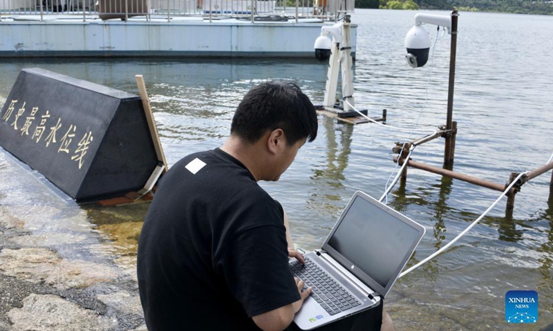 A staff member installs a video monitoring system for the highest water level of the Miyun Reservoir in Beijing, capital of China, Aug. 25, 2021. Photo:Xinhua