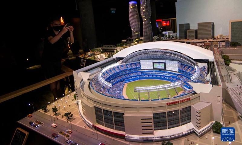 A man takes photos of Little Rogers Center during Little Canada exhibition in Toronto, Canada, on Aug. 28, 2021. With several geographically-themed areas, the immersive exhibition Little Canada offered visitors a bird's eye view of Canada with the mostly 1:87 scale replica buildings here from this August. (Photo by Zou Zheng/Xinhua)