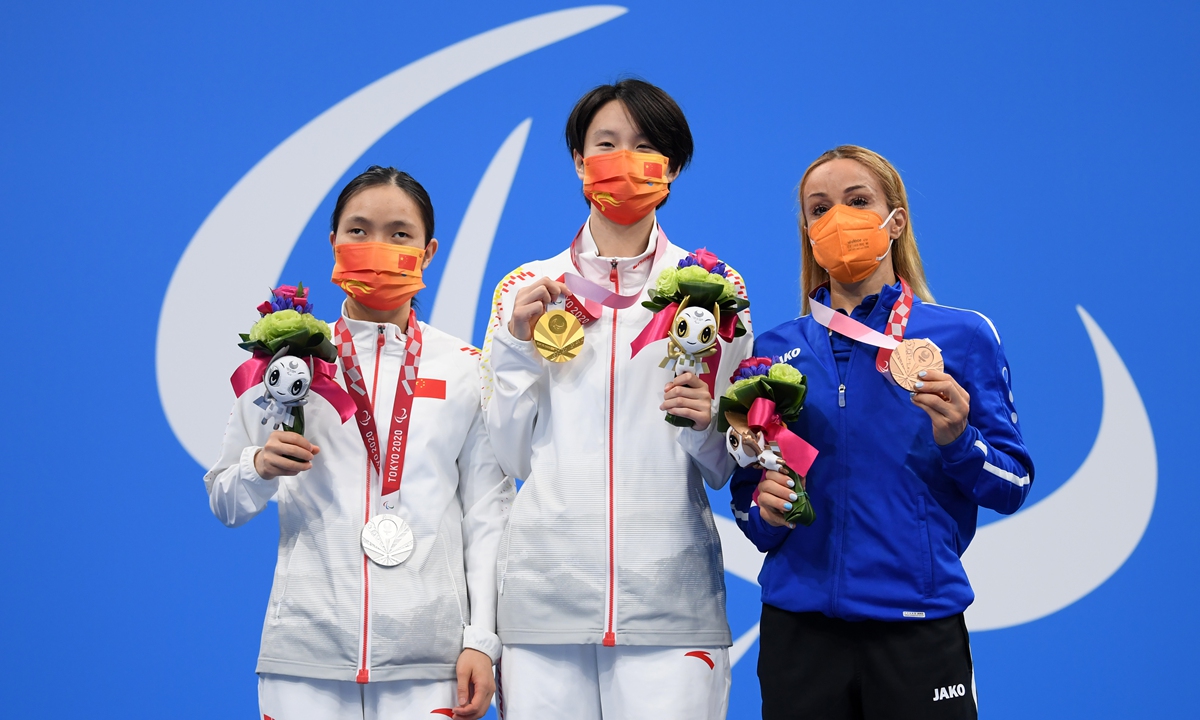 Gold medalist Ma Jia (center), silver medalist Li Guizhi (left) and bronze medalist Karolina Pelendritou of Cyprus pose on the podium after the final of the women's 50-meter freestyle - S11 on Sunday. Photo: VCG