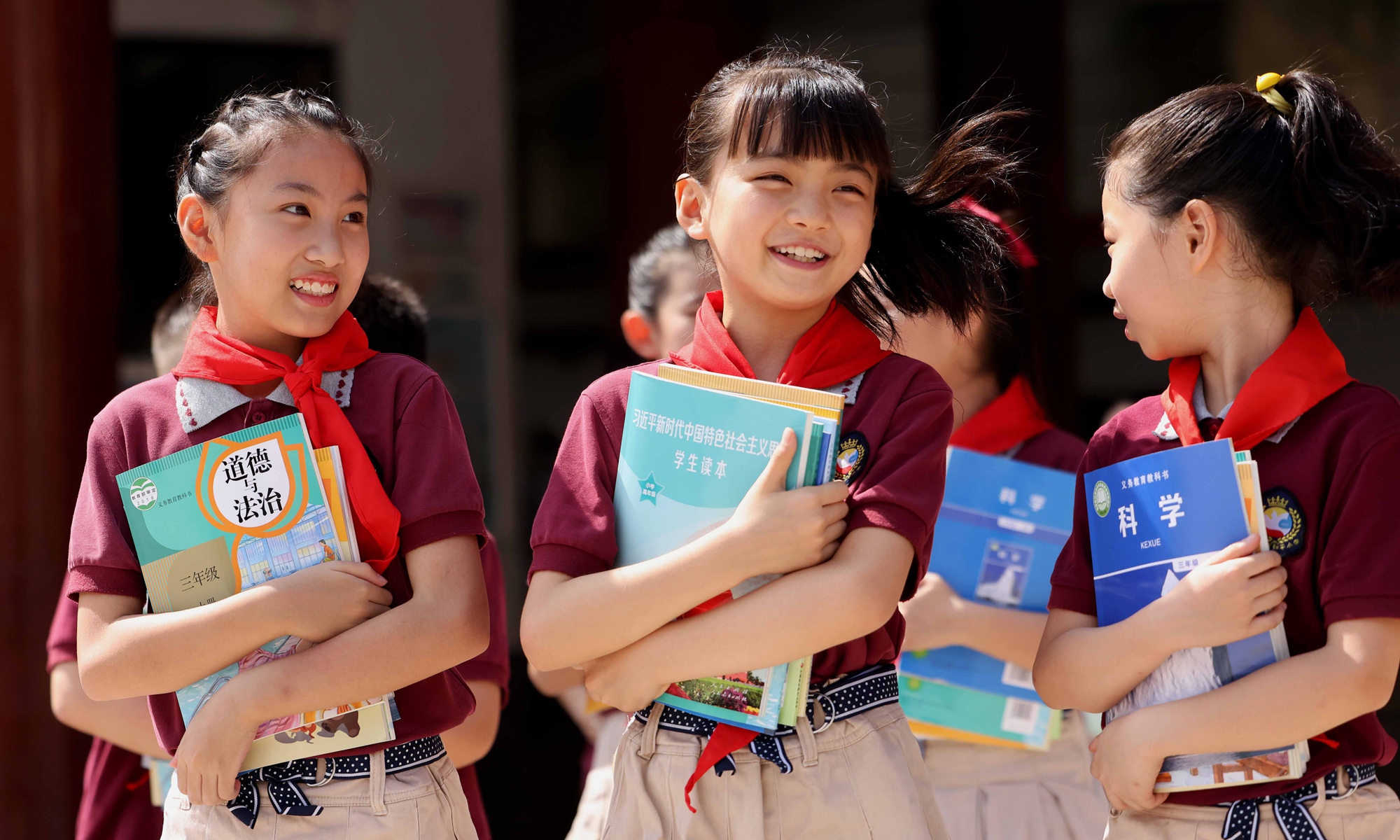 Students run around the Heping Primary School in Yaohai district of Hefei, East China's Anhui Province on Monday, holding new textbooks they have just received. Schools in China will begin the new semester on Wednesday. Photo: IC
