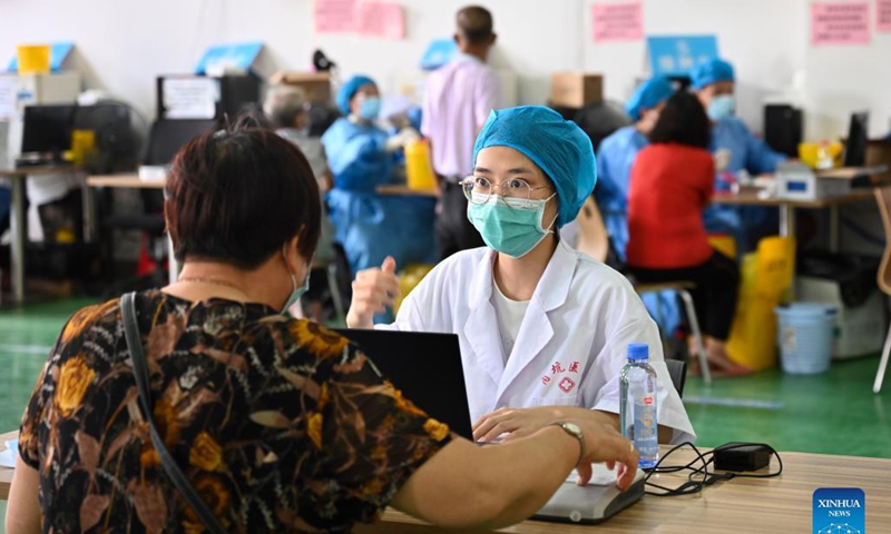 A medical worker registers information of an old woman who comes to receive a COVID-19 vaccine in Neikeng Town in Jinjiang City, southeast China's Fujian Province, Aug. 31, 2021. Photo: Xinhua 