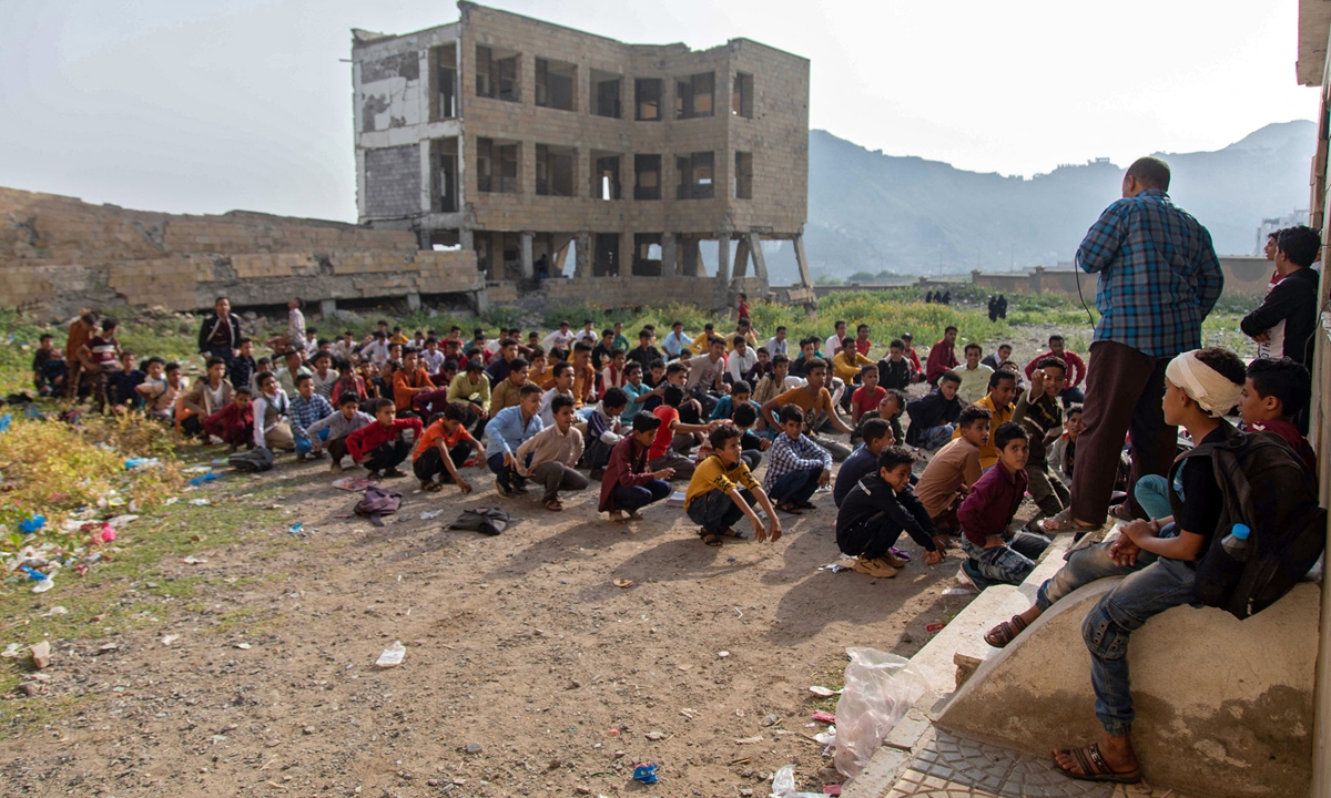 Yemeni students attend class in their destroyed school compound on the first day of the new academic year in southwestern Yemen's Taez on Monday. At least 40 pro-government soldiers from the Al Amalikah Brigades were killed in a Houthi rebel missile attack on a military base in southern Yemen on Sunday. Photo: VCG