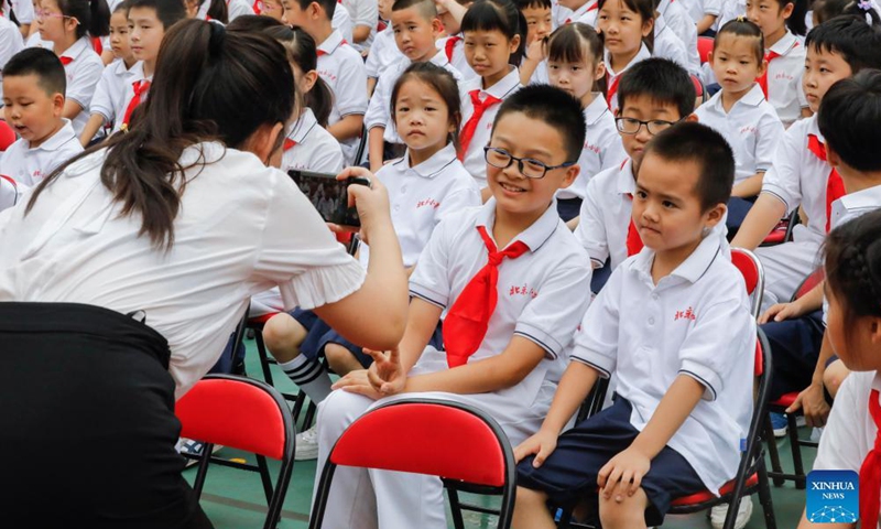 A teacher takes photos for students before the opening ceremony for the new semester at Beijing Primary School Guangwai branch in Beijing, capital of China, Aug. 31, 2021.Photo:Xinhua