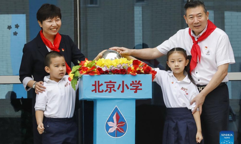 Senior students put the school badge on first year students at the opening ceremony for the new semester at Beijing Primary School Guangwai branch in Beijing, capital of China, Aug. 31, 2021.Photo:Xinhua