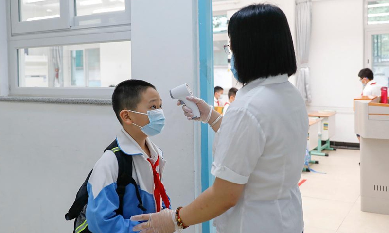 A student has body temperature checked before entering the classroom at Beijing Primary School Guangwai branch in Beijing, capital of China, Aug. 31, 2021.Photo:Xinhua