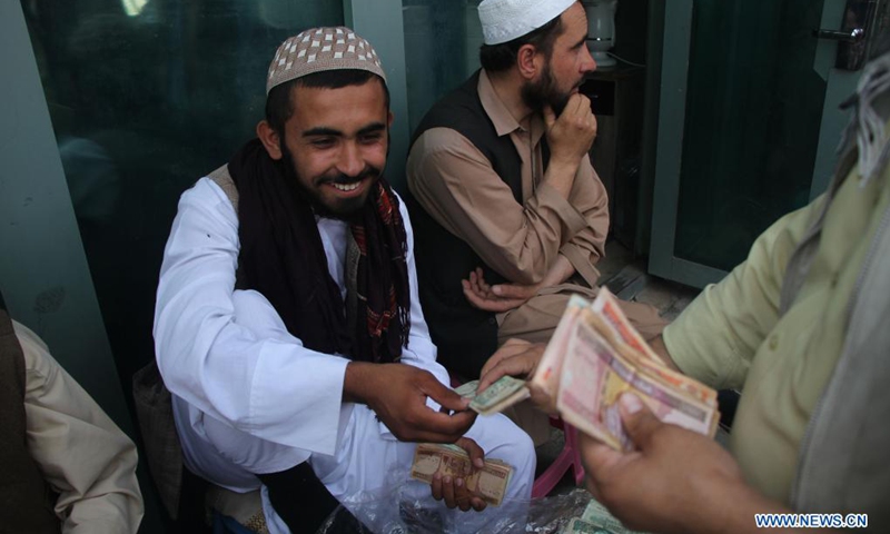 Afghan men exchange money at the main money exchange market after reopening in Kabul, capital of Afghanistan, Sept. 4, 2021. The main money exchange market in Kabul, capital of Afghanistan reopened on Saturday, 10 days after Taliban takeover as a banking crisis still exists in the Asian country, a local source said.(Photo: Xinhua)