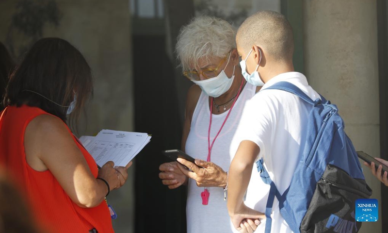 Teachers check the SafePass of a student at the school on the first day of a new school year in Nicosia, Cyprus, Sept. 7, 2021. (Photo: Xinhua)