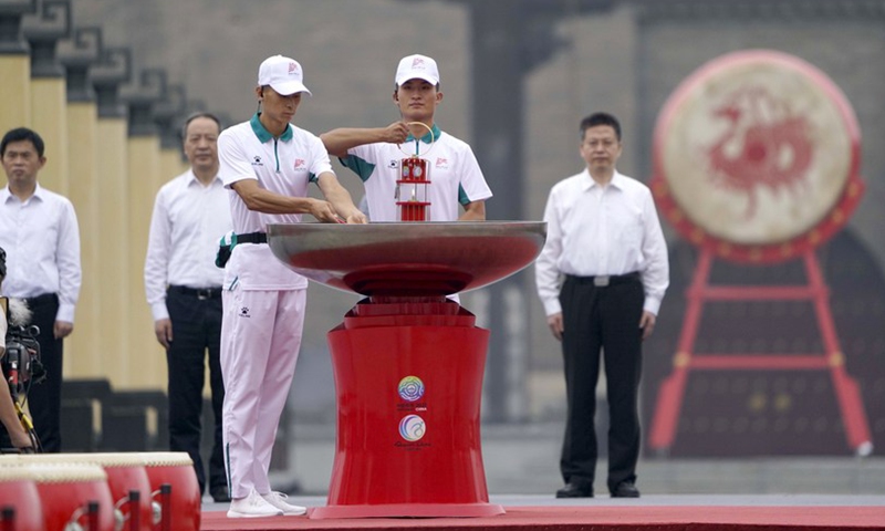 A staff member (4th L) holds the flame lantern before lighting the cauldron prior to the torch relay for China's 14th National Games, 11th National Paralympic Games, and eighth National Special Olympics in Xi'an, Shaanxi Province, Aug. 16, 2021. Photo: Xinhua 