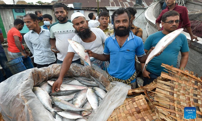 A vendor shows Hilsa fish at a fish landing station in Chandpur, Bangladesh, Sept. 7, 2021.Photo:Xinhua