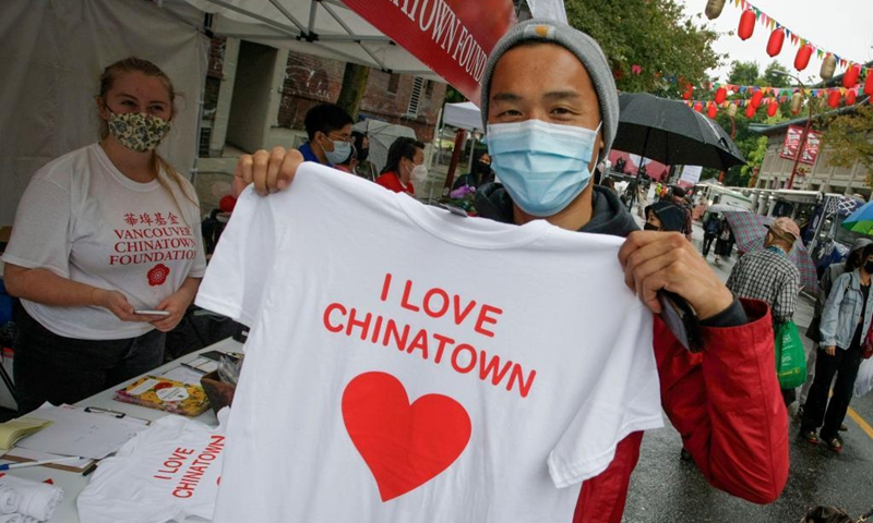 A man shows a T-shirt he purchased during the Light Up Chinatown event at Chinatown in Vancouver, British Columbia, Canada, Sept. 11, 2021. The two-day event hosted by Chinatown Business Improvement Association featuring live entertainment, food trucks, lights and decorations. The organizer wishes to bring back tourists and shoppers as the businesses are impacted by the COVID-19 pandemic and anti-Asian hate crimes over the past months.Photo: Xinhua