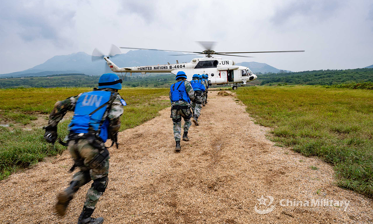 Chinese peacekeeping special operations soldiers of the quick reaction force (QRF) disembark from an off-road tactical armored vehicle and rush to board a transport helicopter during the lane training stage of the Shared Destiny-2021 UN peacekeeping field training exercise in Queshan, Henan Province on September 9, 2021. (eng.chinamil.com.cn/Photo by Wan Quan)