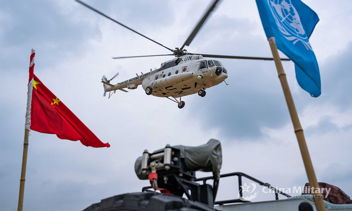 A transport helicopter carrying special operations soldiers hovers at an ultra-low altitude to provide security to a transport convoy during the lane training stage of the Shared Destiny-2021 UN peacekeeping field training exercise in Queshan, Henan Province on September 9, 2021. (eng.chinamil.com.cn/Photo by Wan Quan)