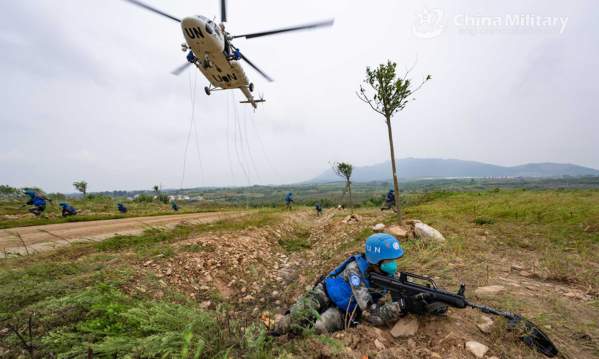 Chinese peacekeeping special operations soldiers of the quick reaction force (QRF) provide security to each other and prepare to engage mock ememies after fast-roping from a transport helicopter during the lane training stage of the Shared Destiny-2021 UN peacekeeping field training exercise in Queshan, Henan Province on September 9, 2021. (eng.chinamil.com.cn/Photo by Wan Quan)