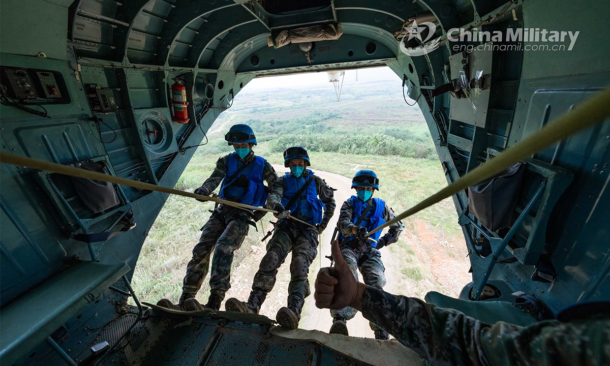 Eight Chinese peacekeeping special operations soldiers of the quick reaction force (QRF) fast rope from the side, rear and floor hatches of a transport helicopter simultaneously during the lane training stage of the Shared Destiny-2021 UN peacekeeping field training exercise in Queshan, Henan Province on September 9, 2021. (eng.chinamil.com.cn/Photo by Wan Quan)