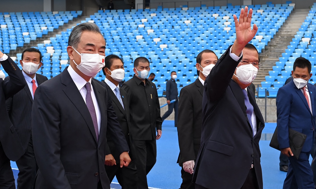 Chinese State Councilor and Foreign Minister Wang Yi (left) walks with Cambodian Prime Minister Hun Sen inside a China-funded stadium in Phnom Penh after the venue was handed over to Cambodian on Sunday. Photo: AFP