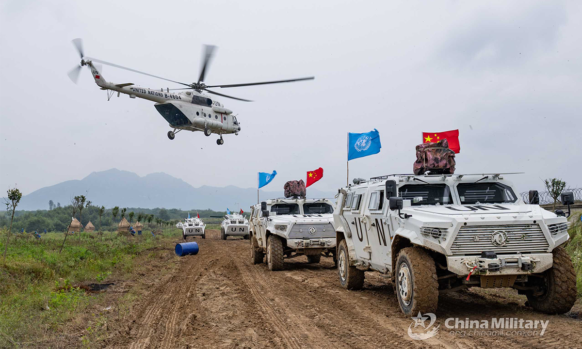 A transport helicopter carrying special operations soldiers hovers at an ultra-low altitude to provide security to a transport convoy during the lane training stage of the Shared Destiny-2021 UN peacekeeping field training exercise in Queshan, Henan Province on September 9, 2021. (eng.chinamil.com.cn/Photo by Wan Quan)