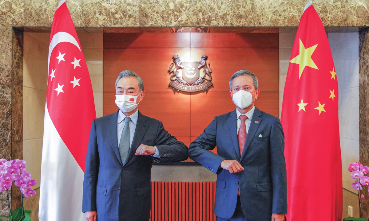 Chinese State Councilor and Foreign Minister Wang Yi (left) bumps elbows with Singaporean Foreign Minister Vivian Balakrishnan during Wang's visit to the country on Monday. (See story on Page 3) Photos: AFP