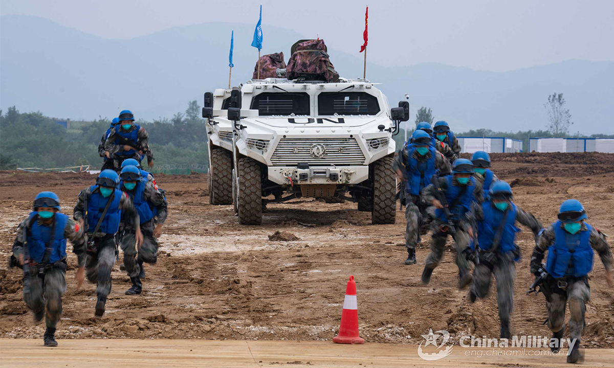 Chinese peacekeeping special operations soldiers of the quick reaction force (QRF) disembark from an off-road tactical armored vehicle and rush to board a transport helicopter during the lane training stage of the Shared Destiny-2021 UN peacekeeping field training exercise in Queshan, Henan Province on September 9, 2021. (eng.chinamil.com.cn/Photo by Wan Quan)