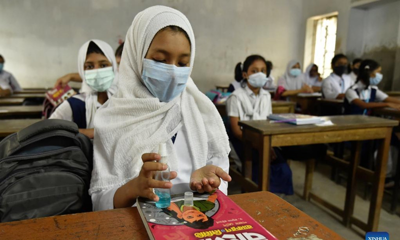 A student disinfects her hand at a school in Dhaka, Bangladesh, Sept. 14, 2021. Schools and colleges in Bangladesh reopened on Sunday after being closed for more than one and a half year as fresh COVID-19 cases have begun to fall. Photo:Xinhua