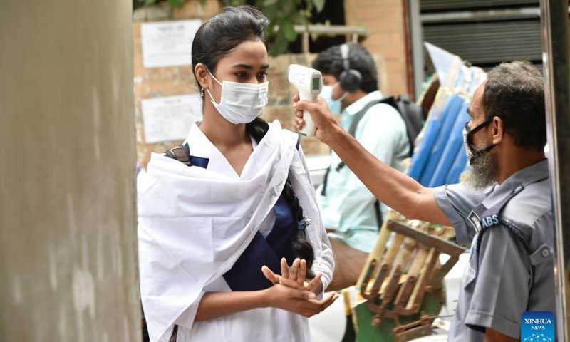 A student has her body temperature checked at a school in Dhaka, Bangladesh, Sept. 14, 2021. Schools and colleges in Bangladesh reopened on Sunday after being closed for more than one and a half year as fresh COVID-19 cases have begun to fall. Photo:Xinhua