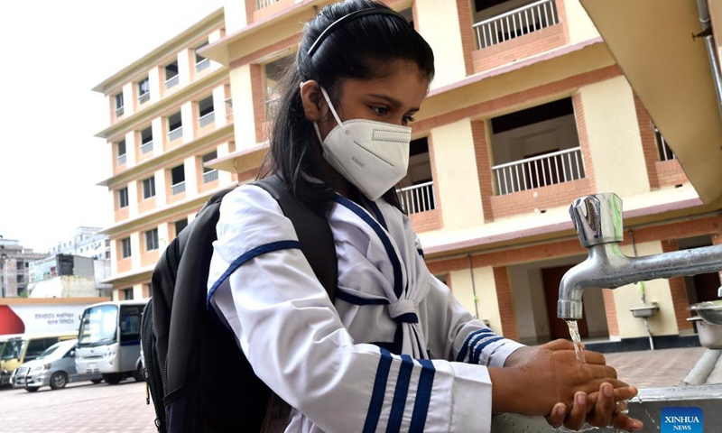 A student washes her hands before entering a school in Dhaka, Bangladesh, Sept. 14, 2021. Schools and colleges in Bangladesh reopened on Sunday after being closed for more than one and a half year as fresh COVID-19 cases have begun to fall. Photo:Xinhua