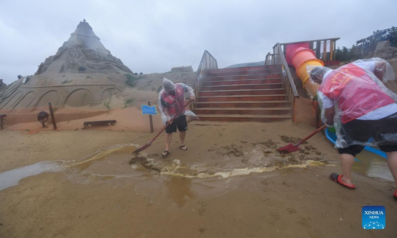 Volunteers help with drainage work at the Nansha beach resort in Zhoushan, east China's Zhejiang Province, Sept. 14, 2021. The disaster relief work is underway in Zhoushan as the influence of Typhoon Chanthu weakens. Photo: Xinhua 