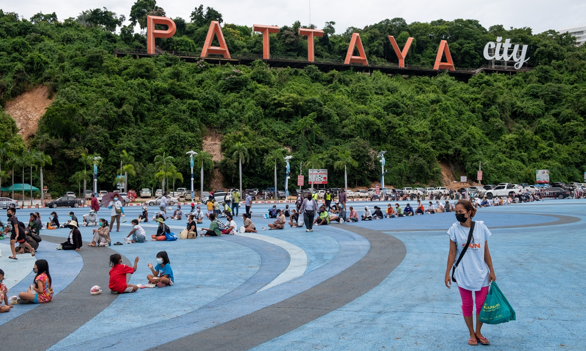 People wait in line to receive food donations in Pattaya on Saturday. The Thai government has pushed back plans to reopen Pattaya and other major cities in the country to international travel, in light of the COVID-19 emergency and vaccination rates falling short of target. Thailand plans to reopen more destinations for fully-vaccinated travelers from October 1. Photo: VCG