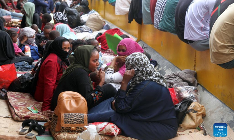 Asylum-seekers gather in front of the United Nations High Commissioner for Refugees in Al-Sarraj, Tripoli, Libya, on Oct. 9, 2021. The United Nations High Commissioner for Refugees (UNHCR) on Saturday provided medical assistance for a group of asylum-seekers after they escaped from a detention center in Tripoli. Thousands of asylum-seekers fled a detention center in Tripoli and headed to the Community Day Center of UNHCR, of which services were recently suspended due to the security situation.(Photo: Xinhua)