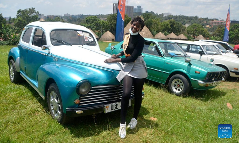 A woman poses for photos at the Independence Day Vintage Car Show in Kampala, Uganda, Oct. 9, 2021. Over 70 cars on Saturday were displayed during the event.(Photo: Xinhua)