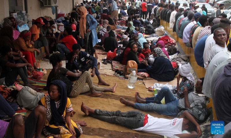 Asylum-seekers gather in front of the United Nations High Commissioner for Refugees in Al-Sarraj, Tripoli, Libya, on Oct. 9, 2021. The United Nations High Commissioner for Refugees (UNHCR) on Saturday provided medical assistance for a group of asylum-seekers after they escaped from a detention center in Tripoli. Thousands of asylum-seekers fled a detention center in Tripoli and headed to the Community Day Center of UNHCR, of which services were recently suspended due to the security situation.(Photo: Xinhua)