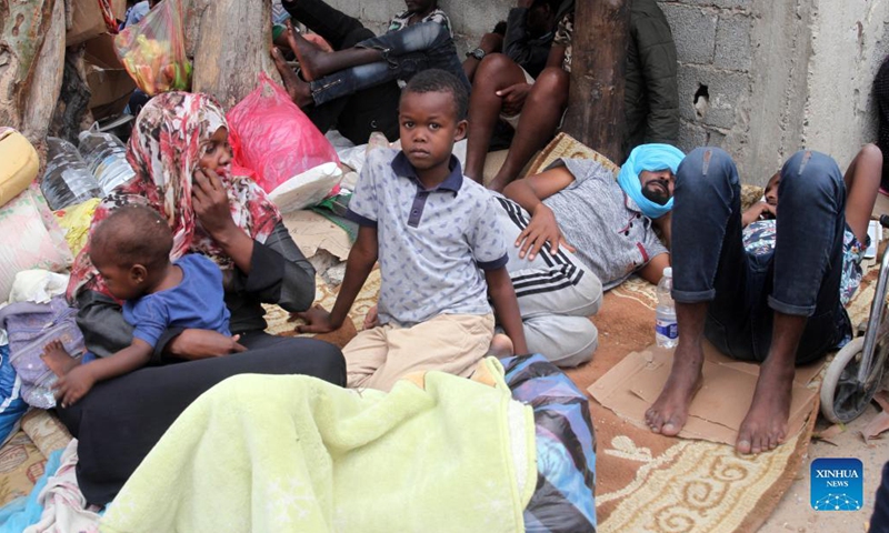 Asylum-seekers gather in front of the United Nations High Commissioner for Refugees in Al-Sarraj, Tripoli, Libya, on Oct. 9, 2021. The United Nations High Commissioner for Refugees (UNHCR) on Saturday provided medical assistance for a group of asylum-seekers after they escaped from a detention center in Tripoli. Thousands of asylum-seekers fled a detention center in Tripoli and headed to the Community Day Center of UNHCR, of which services were recently suspended due to the security situation.(Photo: Xinhua)