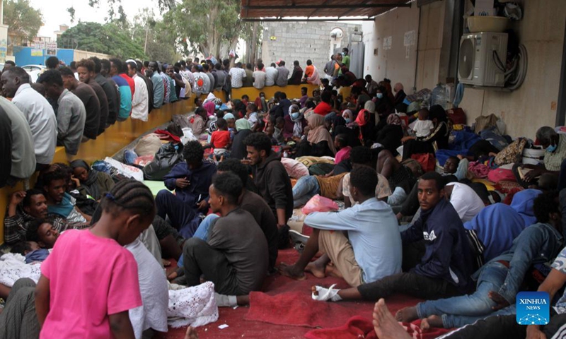 Asylum-seekers gather in front of the United Nations High Commissioner for Refugees in Al-Sarraj, Tripoli, Libya, on Oct. 9, 2021. The United Nations High Commissioner for Refugees (UNHCR) on Saturday provided medical assistance for a group of asylum-seekers after they escaped from a detention center in Tripoli. Thousands of asylum-seekers fled a detention center in Tripoli and headed to the Community Day Center of UNHCR, of which services were recently suspended due to the security situation.(Photo: Xinhua)