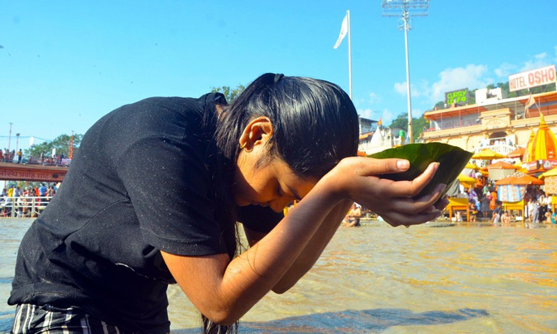 A girl prays to sun god after taking a holy dip in Ganges river on the occasion of Sharad and Laxmi purnima or full moon in the town of Haridwar, northern Indian state of Uttarakhand on Oct. 20, 2021.(Photo: Xinhua)